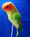 Flerfarvet fugl på pind. Ca. 14 cm fra hoved til hale.