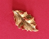 Et stk flot dekorations metal guldfarvet blad. Ca. 4,8 cm x 2,5 cm.