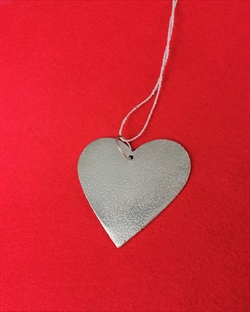 Et stk. "antik" look sølvfarvet fladt hjerte til ophængning. Ø ca. 7 cm.