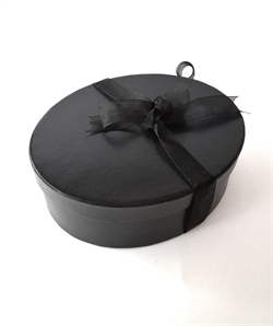 Sort gaveæske med låg. Sort bånd. Oval. Ca. L 20 x 16 cm H. 6,5 cm.