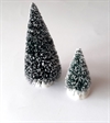 2 små juletræ. H. ca. 10 + 6 cm. Til pynt ved evt. nissedør eller i snelandskab.
