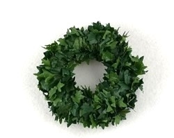 Lille krans med små kunstige blade. Ø ca. 11 cm. Hullet i midten af kransen Ca. Ø 5 cm.