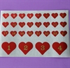 Et ark med kalendertal. Røde hjerter. 1- 24. Hjerterne måler ca. 2  cm. Store kalendertal  1 - 4. Ca. 4,5 cm.
