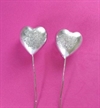 2 stk. Sølvfarvede buttede hjerter med glitter, på tråd. Ca. 4 cm. Fine i dekorationer.